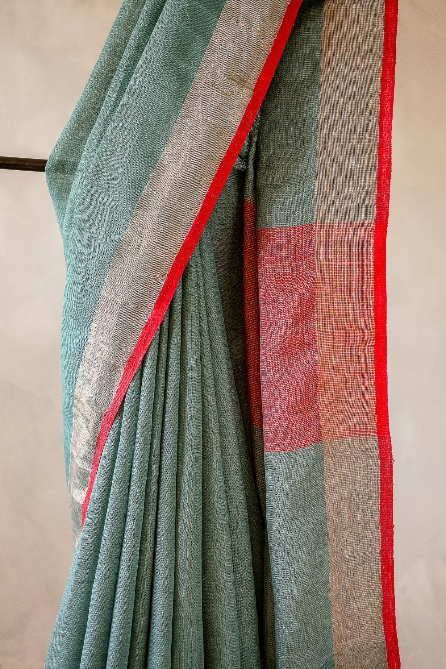 Sage Green Linen Saree with a Vibrant Red Selvedge.